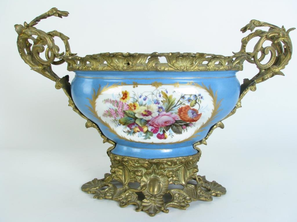 Antique Hand Painted Porcelain Center Bowl: An antique hand painted porcelain center bowl with ornate brass ormolu and base, 22" wide, 15" tall, visible repair on interior bottom of bowl