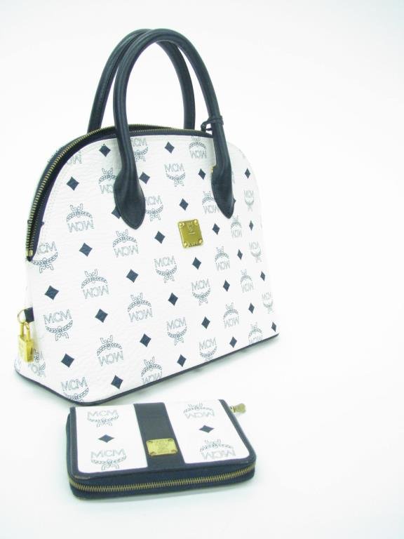 Mode Creation Munich White/Navy Leather Logo Purse: Mode Creation Munich (MCM) white leather and navy logo top handle purse. Navy leather accent trim, gold tone hardware. Zip to closure. Blue fabric logo lining with interior zip pocket. Side lock and k