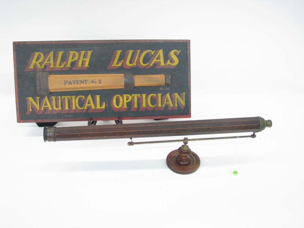 Nautical Telescope and Sign: A nautical telescope and sign including an antique wooden telescope with brass fittings on display stand and a reproduction nautical optician's sign, telescope measures 26.5" long