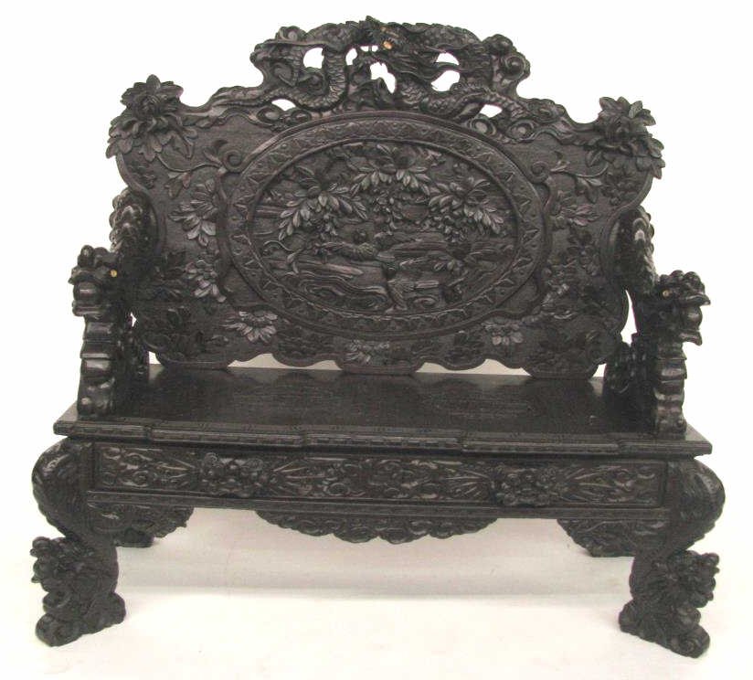 Heavily Carved Oriental Settee: A heavily carved, Oriental settee, depicting dragons, birds and flowers, in raised and relief carvings, mahogany, with dark finish, 52" wide, 48" high, circa mid/late 20th century