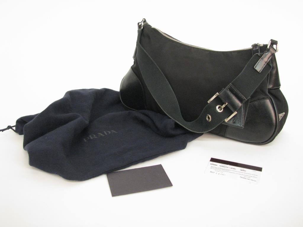 Prada Vintage Black Tessuto Nylon/Leather Baguette: Prada vintage black Tessuto nylon and leather baguette style purse. Adjustable canvas strap with silver tone hardware. Prada logo tag on side. Zip top closure, interior line in black logo material wit