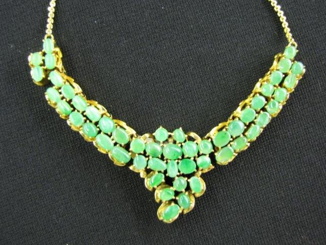 Type A Jadeite Necklace: A type A jadeite necklace, 14" long, with fifty cabochon jadeite stones on gold plated chain and mounting