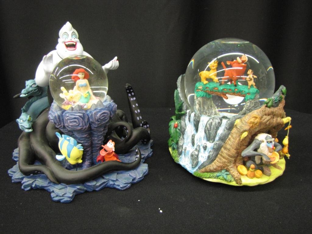 Two Disney Snow Globes: Two Disney Snow Globes depicting scene from the Little Mermaid and a scene from The Lion King, 7" tall, with original boxes