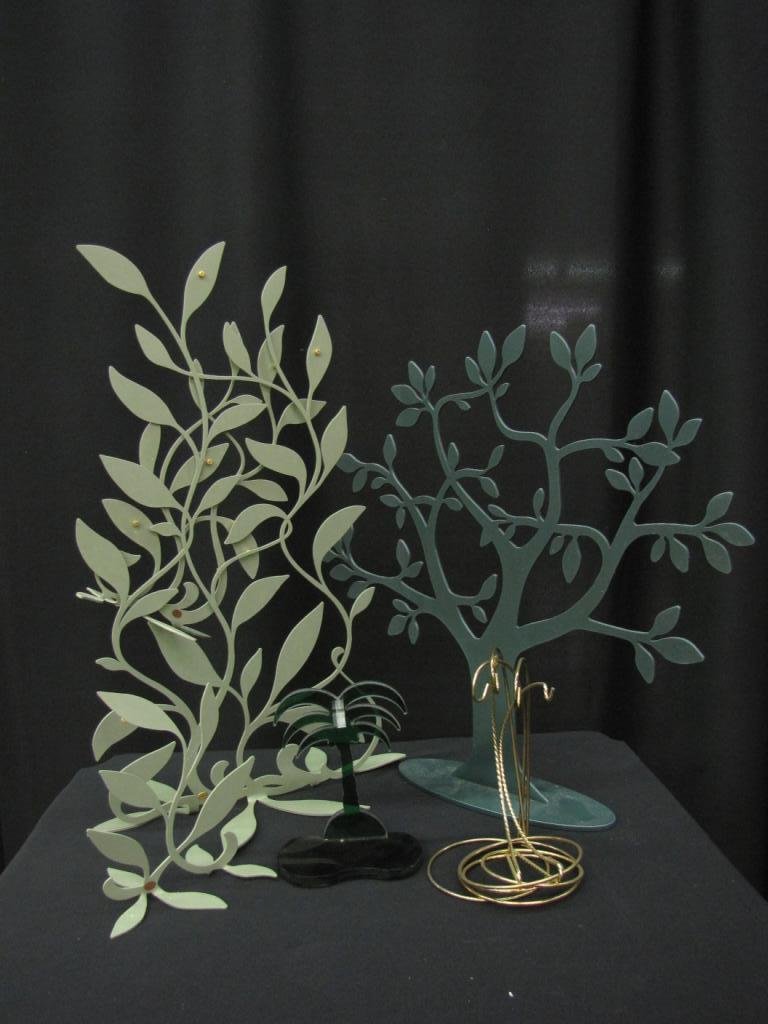 Nine Stands and Ornament Holders: Nine Stands and Ornament Holders including set of two green tree stands, one gray tree stand, one green palm tree stand, and five brass colored metal ornament hangers, 6-22" tall