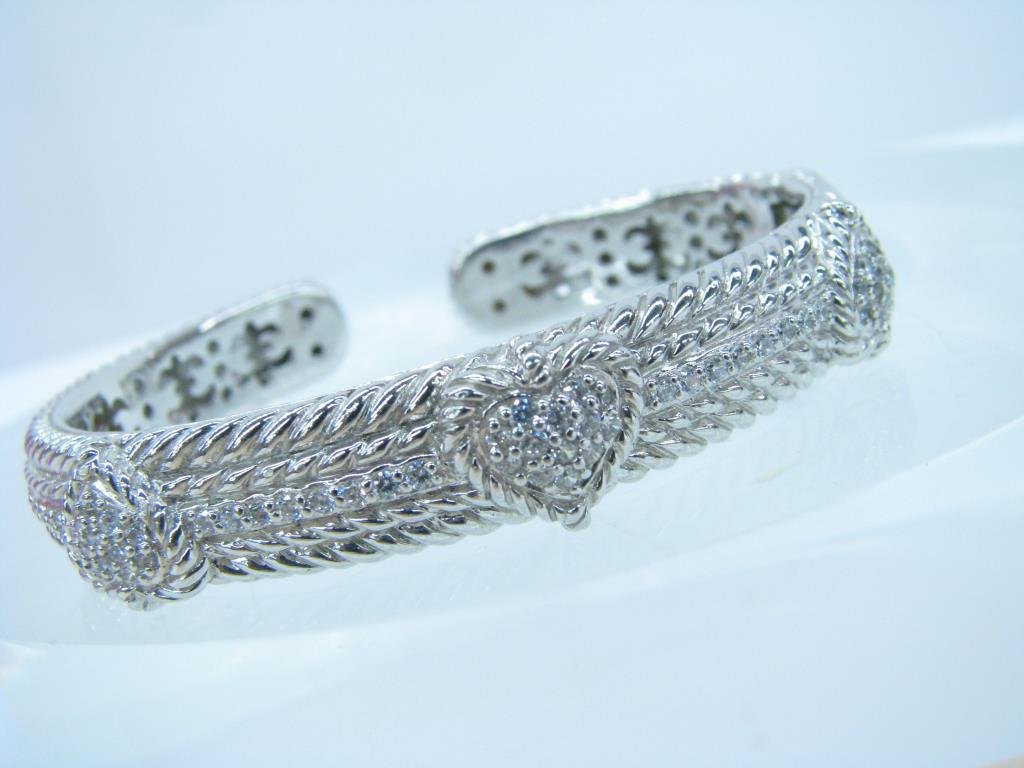 Judith Ripka Sterling Cuff Bracelet: Judith Ripka 925 sterling silver and cubic Zirconia hinged cuff style bracelet. The bracelet is 12 mm in width with hearts that are pave set with cubic Zirconia. The bracelet has a rope design with a 