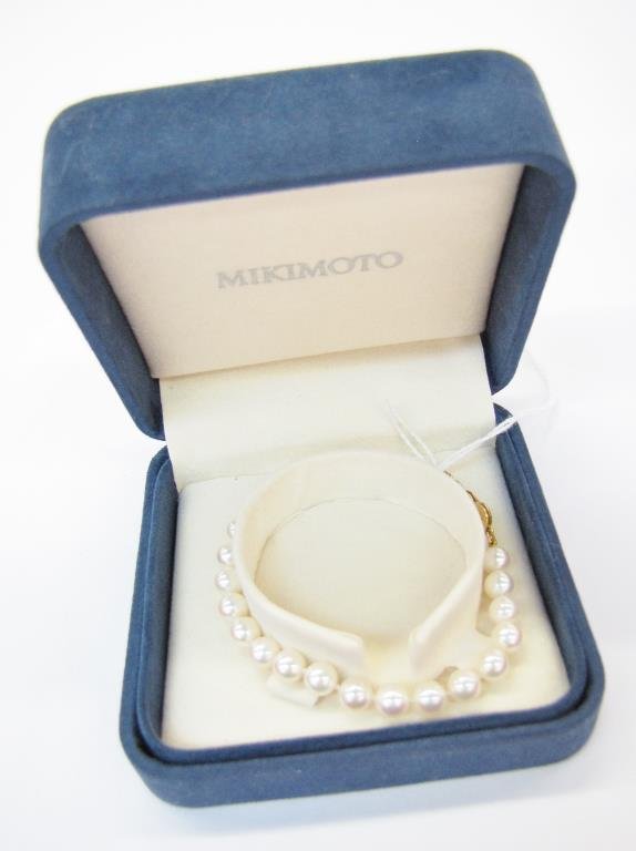 Mikimoto Pearl Bracelet: A 7" long pearl bracelet designed by Mikimoto, with A1 quality pearls measuring 6 x 6.5mm, stamped 18K yellow gold filigree clasp