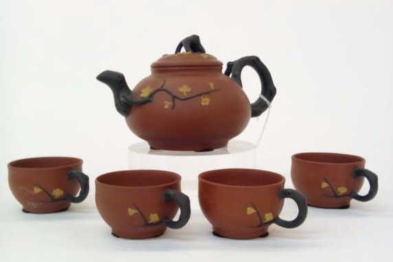 Yi Xing Zisha Teapot and Cups: Yi Xing Zisha Teapot and Cups, teapot and four cups depicting branches and flowers, hallmarks on base of teapot, cups and inside of lid, 7 1/4" x 5" x 4 1/2"