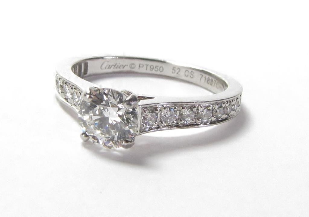 Cartier Platinum Diamond Engagement Ring: A Cartier Platinum ring with .70ct, G color, VVS2 GIA certified round brilliant center diamond solitaire mounted in platinum "1895" pave diamond setting, with Cartier Valuation Report and box, retail 