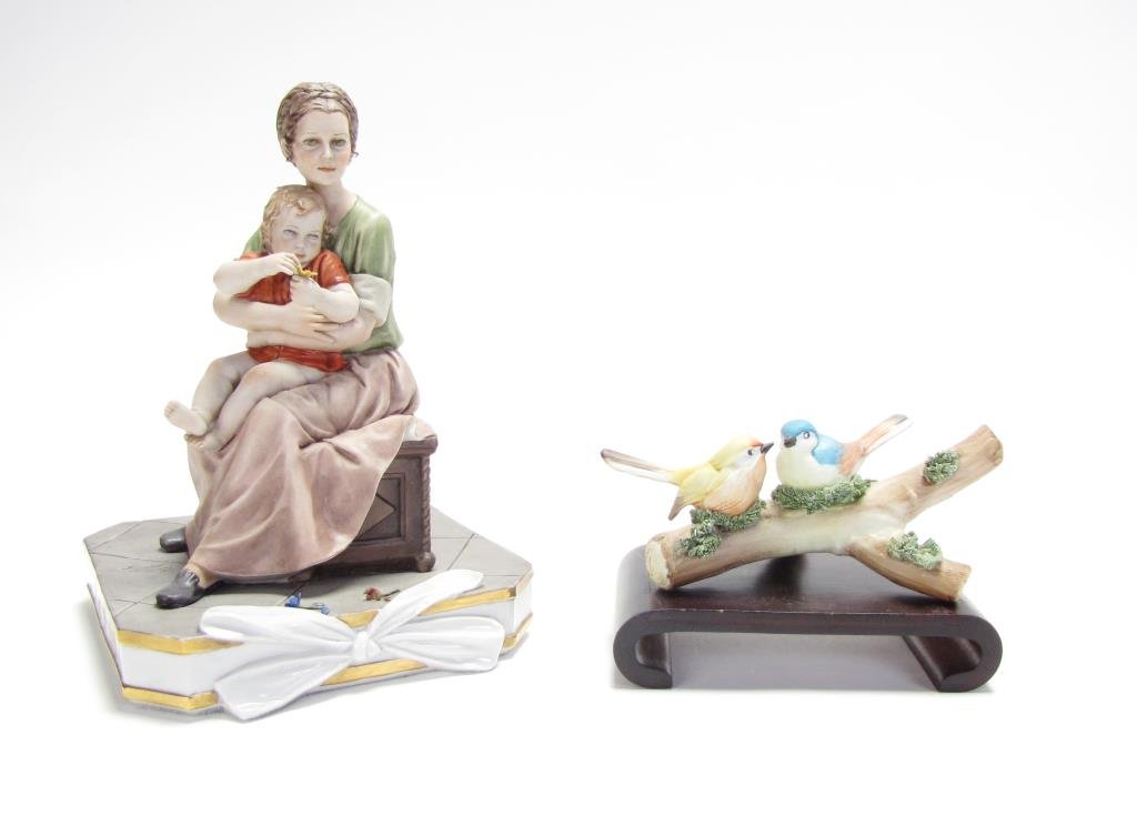 Two Capodimonte Porcelain Figures: Two Capodimonte Porcelain Figures, one depicting seated mother holding child, signed "Sandro Maggioni 1977", 9" tall; the other is two birds on branch, both hallmarked on base