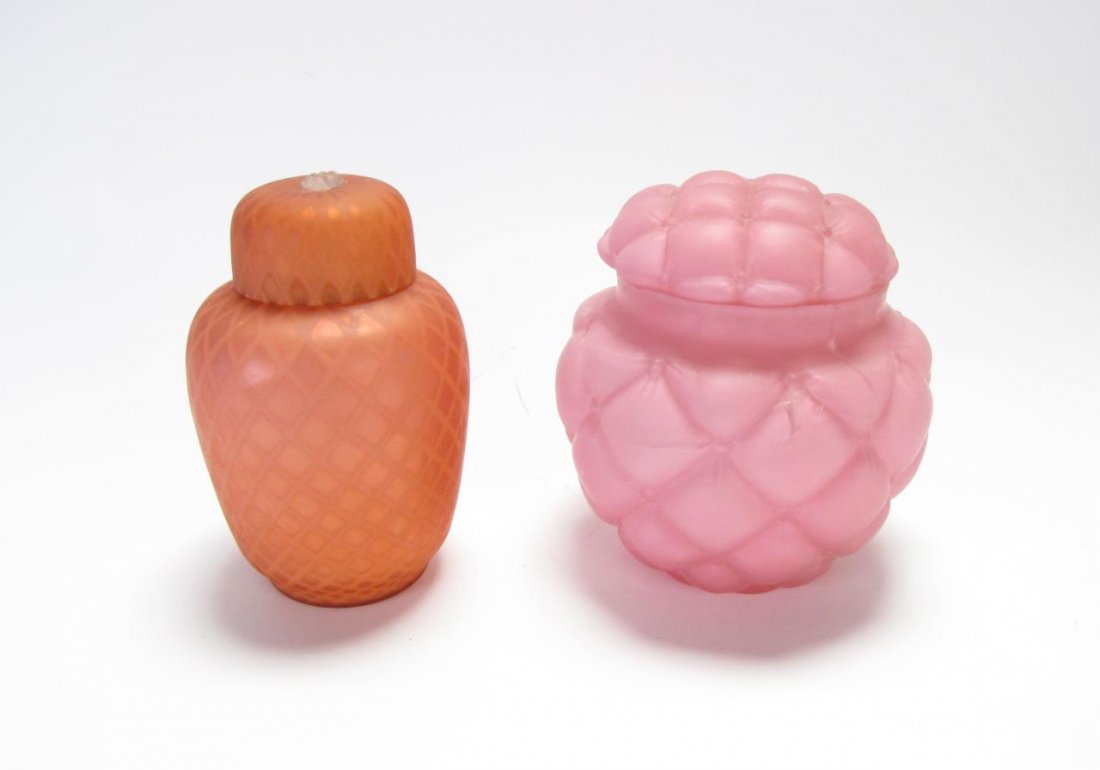 Two Case Glass Lidded Jars: Two Case Glass Lidded Jars including one peach with quilted pattern, lid with applied flower decoration; one pink with quilt and button pattern, 6.5" high Condition, pink jar has a 5" crack repair run