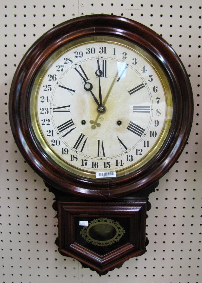 Ansonia Regulator Wall Clock: An antique Ansonia Regulator-style wall clock, Roman numeral and calendar markers on face, reverse painted decoration on door, 16 x 25