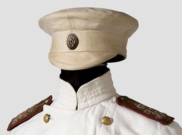 A summer service cap for an officer: Russia, in the style worn ca. 1870 - 1907. Service cap of white linen material, laquered cockade and a small leather visor. Beige lining with traces of wear and a brown leather sweatband. Collector re