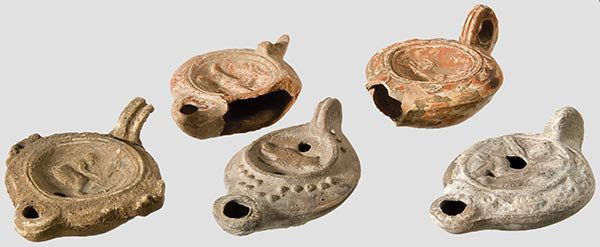 Fünf Bildfeld-Öllampen,: römisch, 2. - 4.Jhdt. n.Chr. Beiger und roter Ton. Unterschiedliche Formen, die Spiegel jeweils mit Hirsch, Wildschwein, Opferszene, Amor und Fabeltier. Zwei Exemplare intakt, die anderen z.T. mit gr