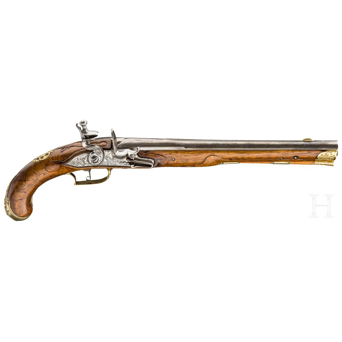 A flintlock pistol, Liege, ca. 1750: Runder und glatter Lauf im Kaliber 17 mm mit Mittelschiene und Messingkorn. Eisernes, mit TrophÃ¤enbÃ¼ndel graviertes Steinschloss. Beschnitzter Nussholzschaft mit gravierter Messinggarnitur. Durc