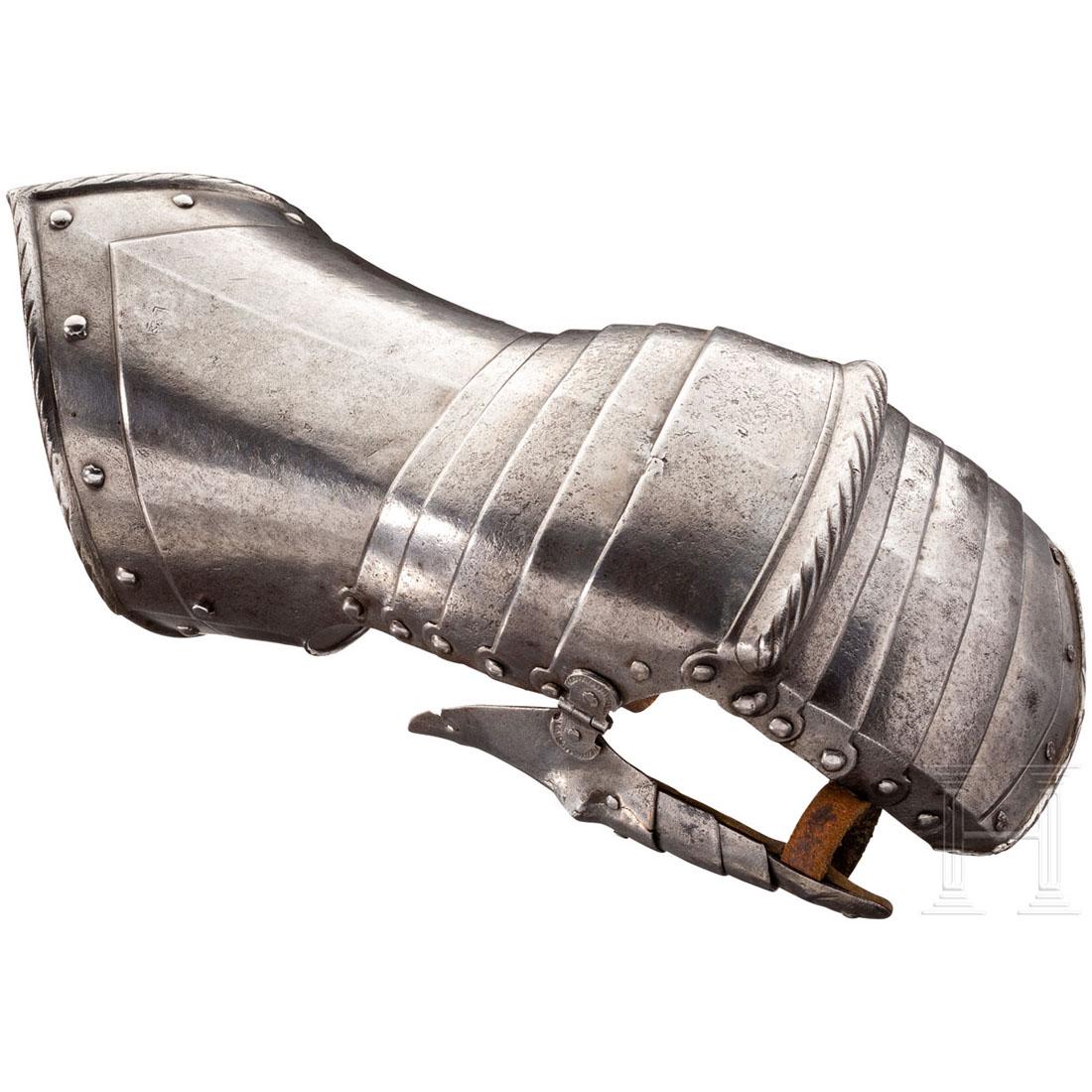 A gautlet, Nuremberg, circa 1550: Auf der GesamtlÃ¤nge mittig gegratete, linke Hentze. FÃ¼nffach geschobener Fingerschutz mit gebÃ¶rdeltem und geschnÃ¼rltem Rand. GeschnÃ¼rlter KnÃ¶chelschutz, fÃ¼nffach geschobener Handr