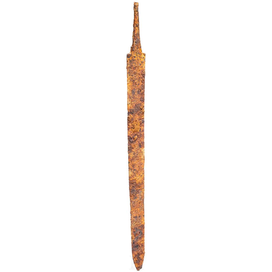 A Late Roman sword, 4th century: Iron sword with broad, strong blade. Both edges are almost parallel over most of the length of the blade. The tang tapers towards the pommel. Corroded, with good iron substance. Without additions. The