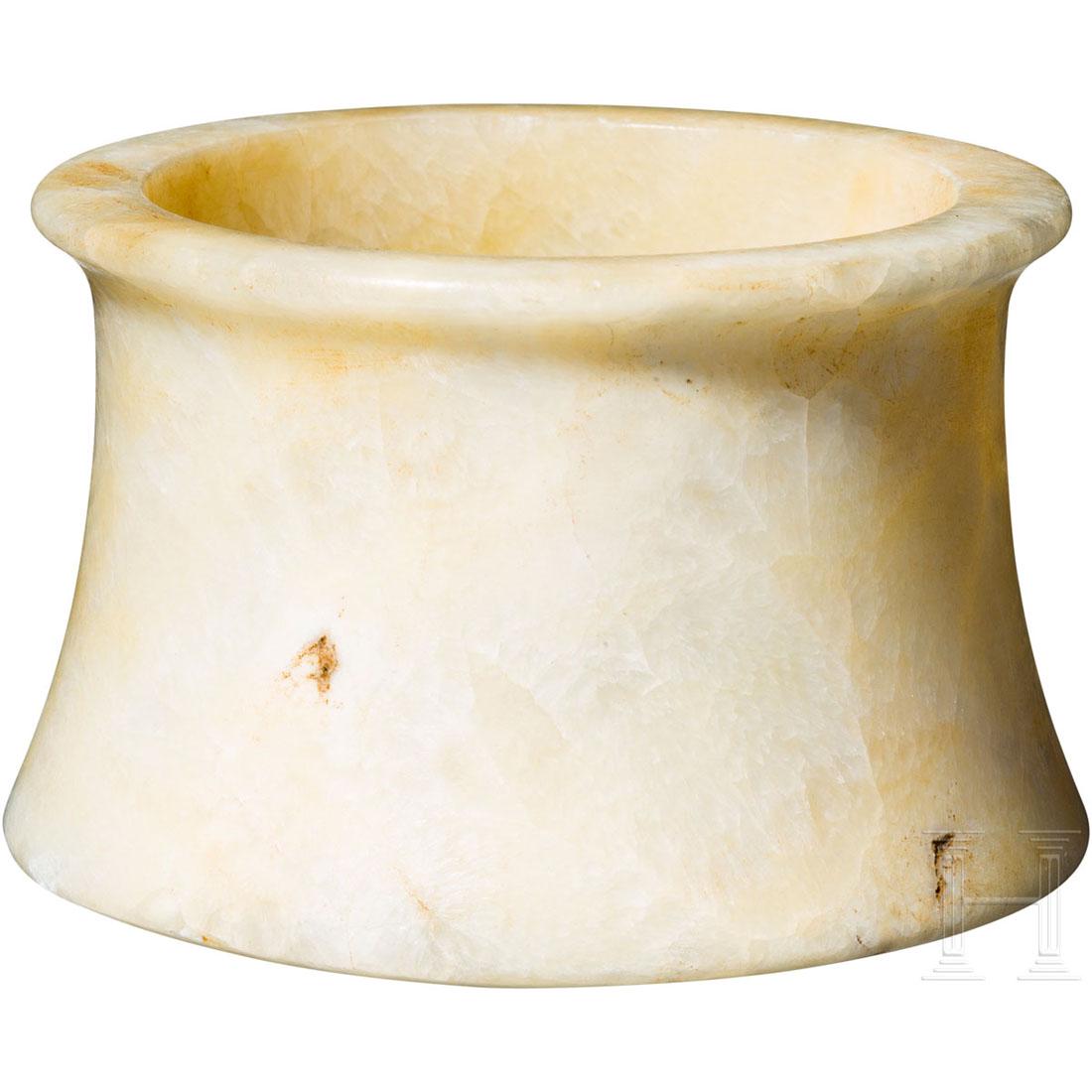 A beautiful Bactrian alabaster vessel, 2nd millenium: Light alabaster vessel with concave body and a plateaued rim. Slightly bumped on the bottom. Beautiful ochre patina. Intact. Height 6.4 cm. Provenance: From a private collection in southern Germany. A