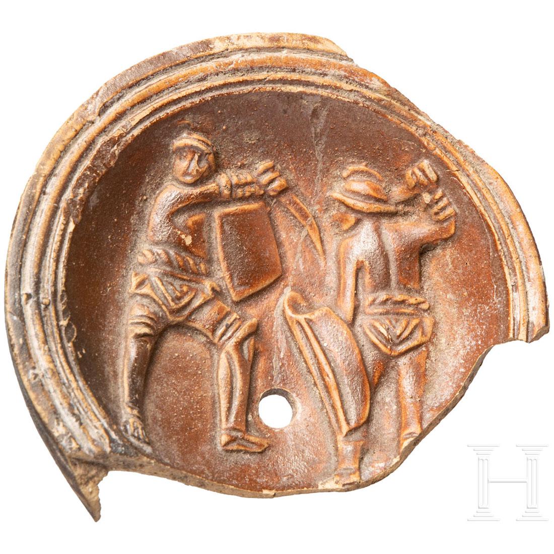 Roman Oil lamp fragment with gladiator depiction, 2nd -: Fragment of the mirror of an oil lamp, dark red fired clay. Scenic depiction of the battle between two gladiators. Glued from two parts. Length 7 cm. Provenance: From a private collection kept in sout