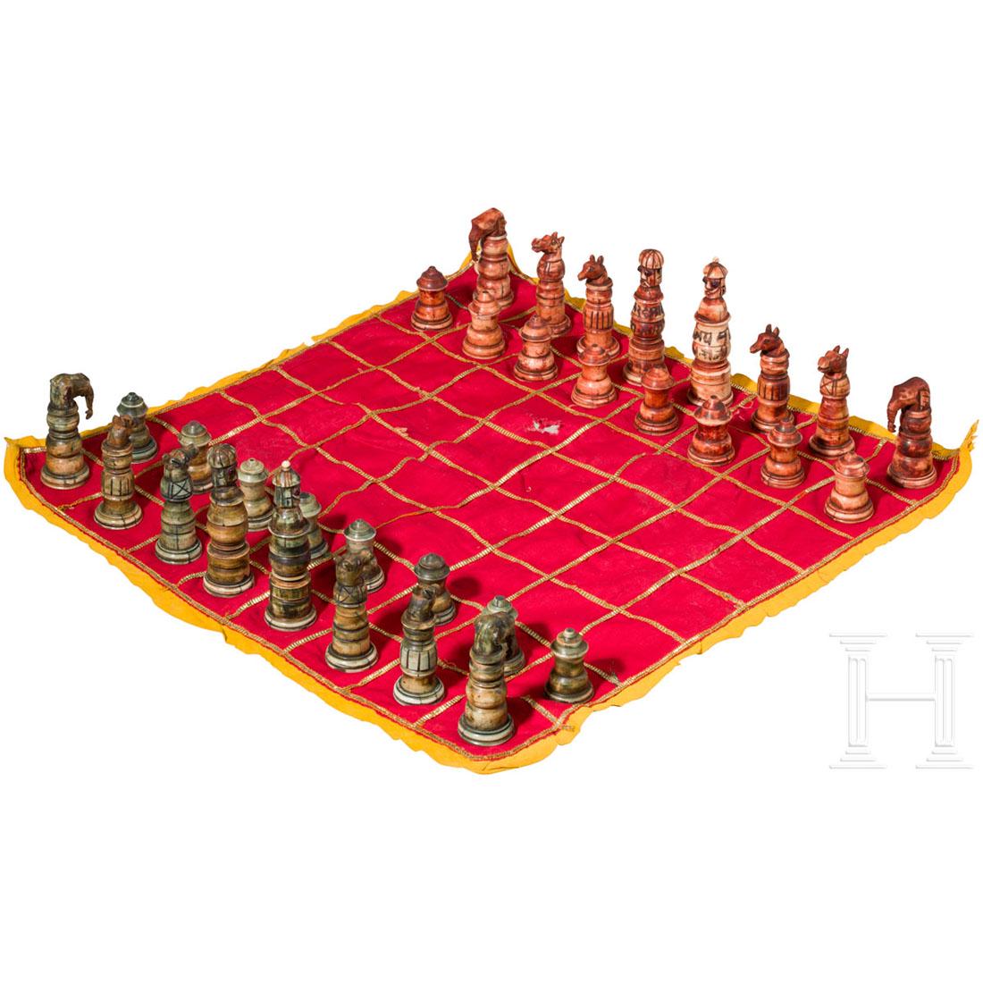 Indian chess pieces made of bone, dated 1884: Komplettes, mehrteilig aus Bein zusammengesetztes, rÃ¶tlich bzw. grÃ¼nlich eingefÃ¤rbtes Set. Der KÃ¶nig und Wesir jeweils mit Kopfbedeckung und roten, eingesetzten Glasaugen. Am "roten" KÃ¶