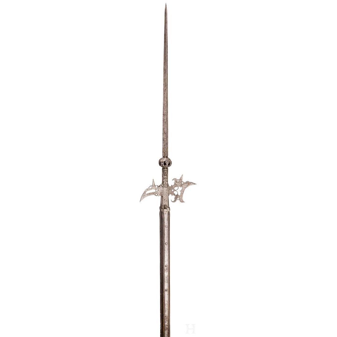 A halberd "Ã la lanterne" of the trabant guard,: Lange, vierkantige StoÃŸklinge Ã¼ber durchbrochen gearbeitetem Baluster mit umlaufend aufgesetzten Maskarons. Am beidseitigen Ansatz jeweils reliefiert geschnittene Figur. Durchbrochen gearbeitete