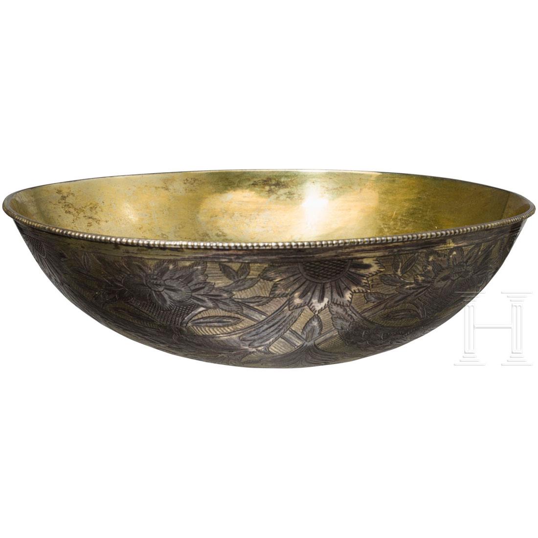 A Greek silver-plated drinking bowl, circa 1820: Flache, teilvergoldete Schale aus WeiÃŸbronze, die AuÃŸenseite mit Silber plattiert. Schauseitig fein gravierter, teilvergoldeter Dekor, die Innenseite vergoldet. HÃ¶he 5,5 cm, Durchmesser 17 cm