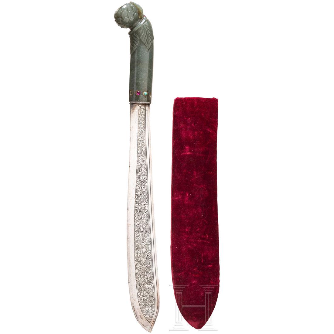 A paper knife with an Indian jade grip, 18th/19th: Silberne, zur Spitze verbreiterte RÃ¼ckenklinge mit beidseitig graviertem Rankendekor. Griff aus grÃ¼ner Jade mit floral geschnittenem Knauf und eingeklebten Rubin- und TÃ¼rkiscabochons (teilwei