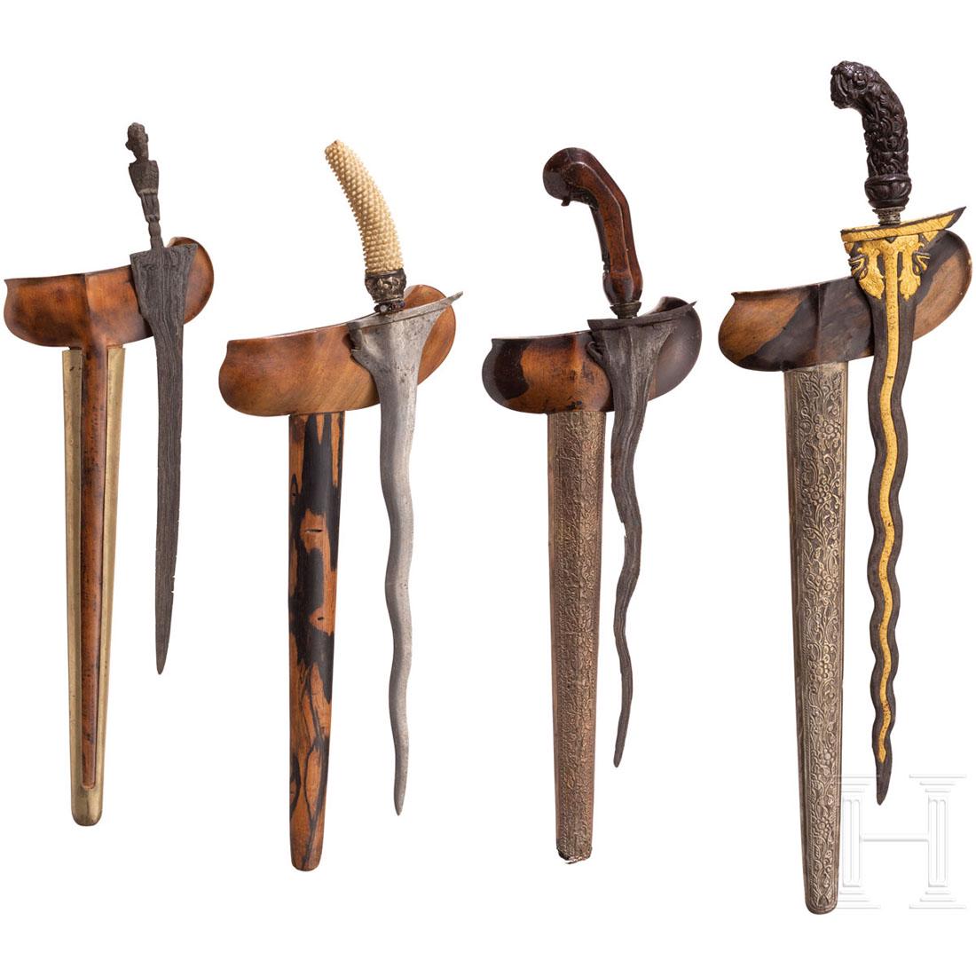 Four krises, Java, around 1900: Gerade und gewellte Rasenerzklingen, eine davon mit geschnittener, vergoldeter Naga-Raia-Schlange. Ein steinbesetztes Mendhak mit silbernem Selut. Griffe aus geschnitztem Holz und Bein, ein Griff eint