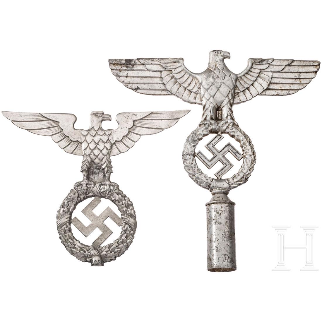 Zwei Fahnenspitzen: Fahnenspitze der NSDAP in Form eines beidseitig plastisch ausgefÃ¼hrten Hoheitsadlers, auf der TÃ¼lle punziert "RZM M3/40/37" (?). Dazu ein abgebrochenes, Ã¤lteres Modell. HÃ¶he 25 bzw. 17,5 c