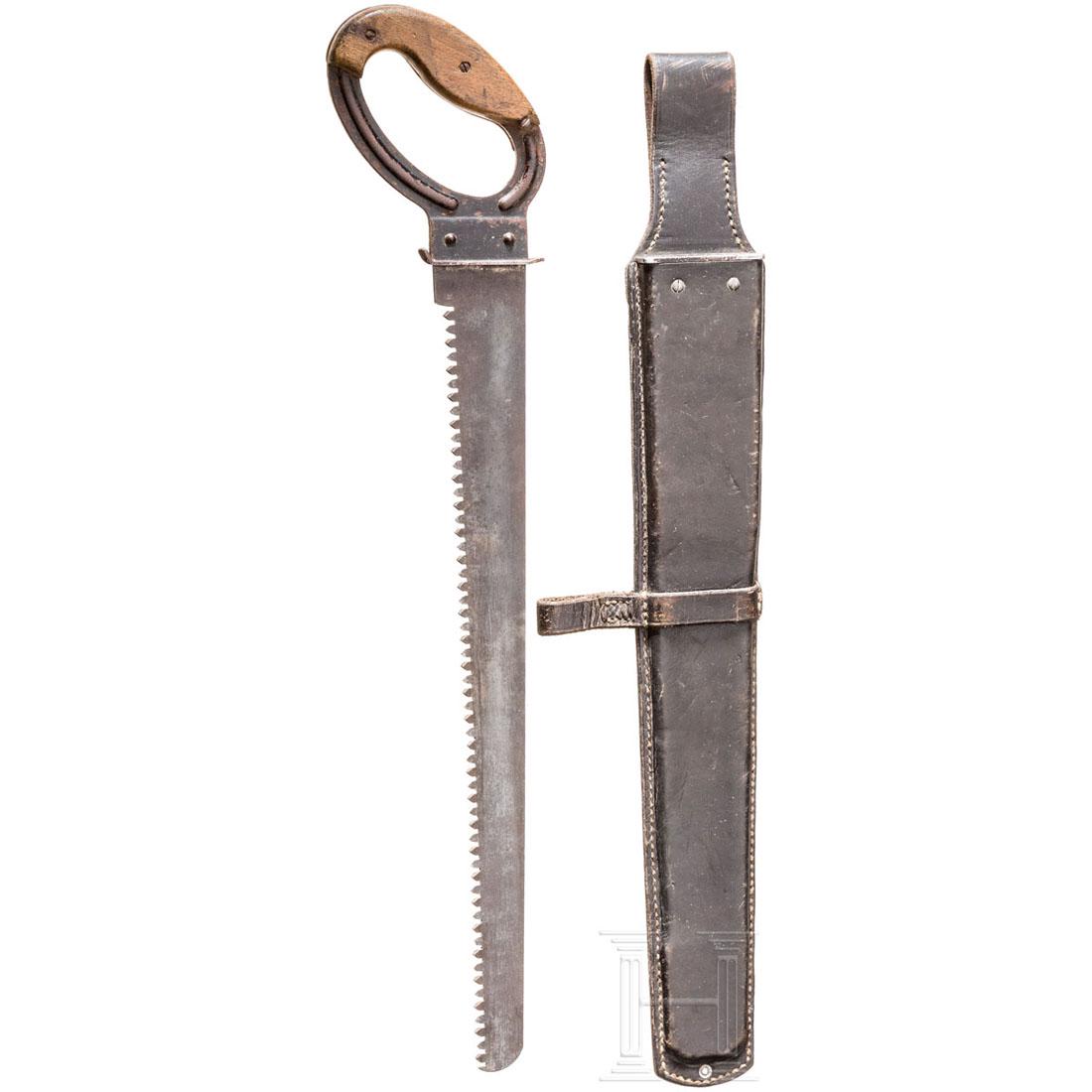 PioniersÃ¤ge mit Tasche: Das SÃ¤geblatt mit Stempel "F.A. Schmidt Remscheid" sowie undeutlicher Abnahme "WaA 145", geschwÃ¤rzter Stahlgriff mit Holzschalen (eine Fehlstelle). LÃ¤nge 55,4 cm. Schwarze Ledertasche mit Her