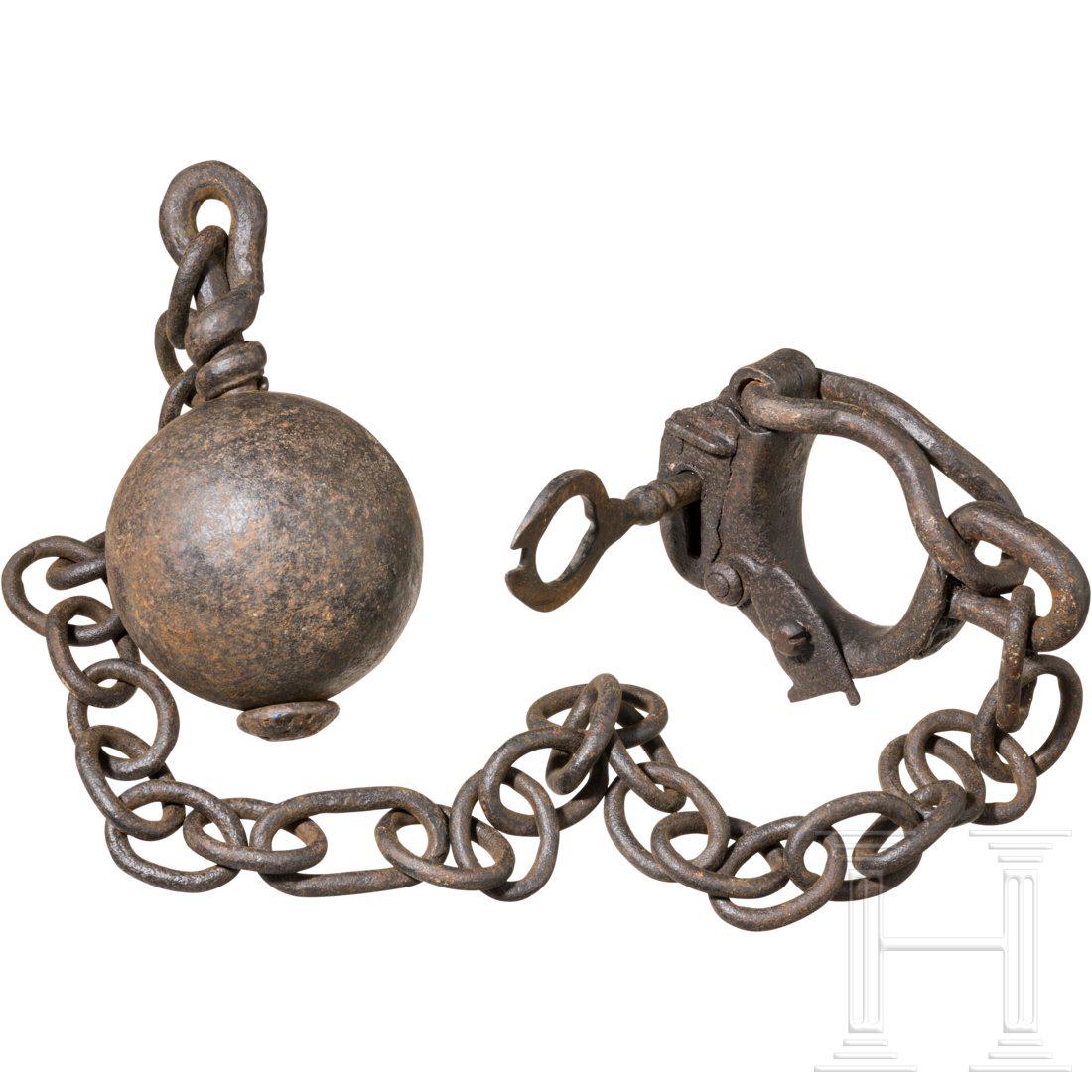 A heavy ball and chain, 18th/19th century: Schwere, gusseiserne Kugel mit drehbarer Ã–se an durchgehender Achse, daran lange Kette aus ovalen Gliedern. Geschmiedete, verschlieÃŸbare FuÃŸschelle mit DornschlÃ¼ssel. Durchmesser der Kuge