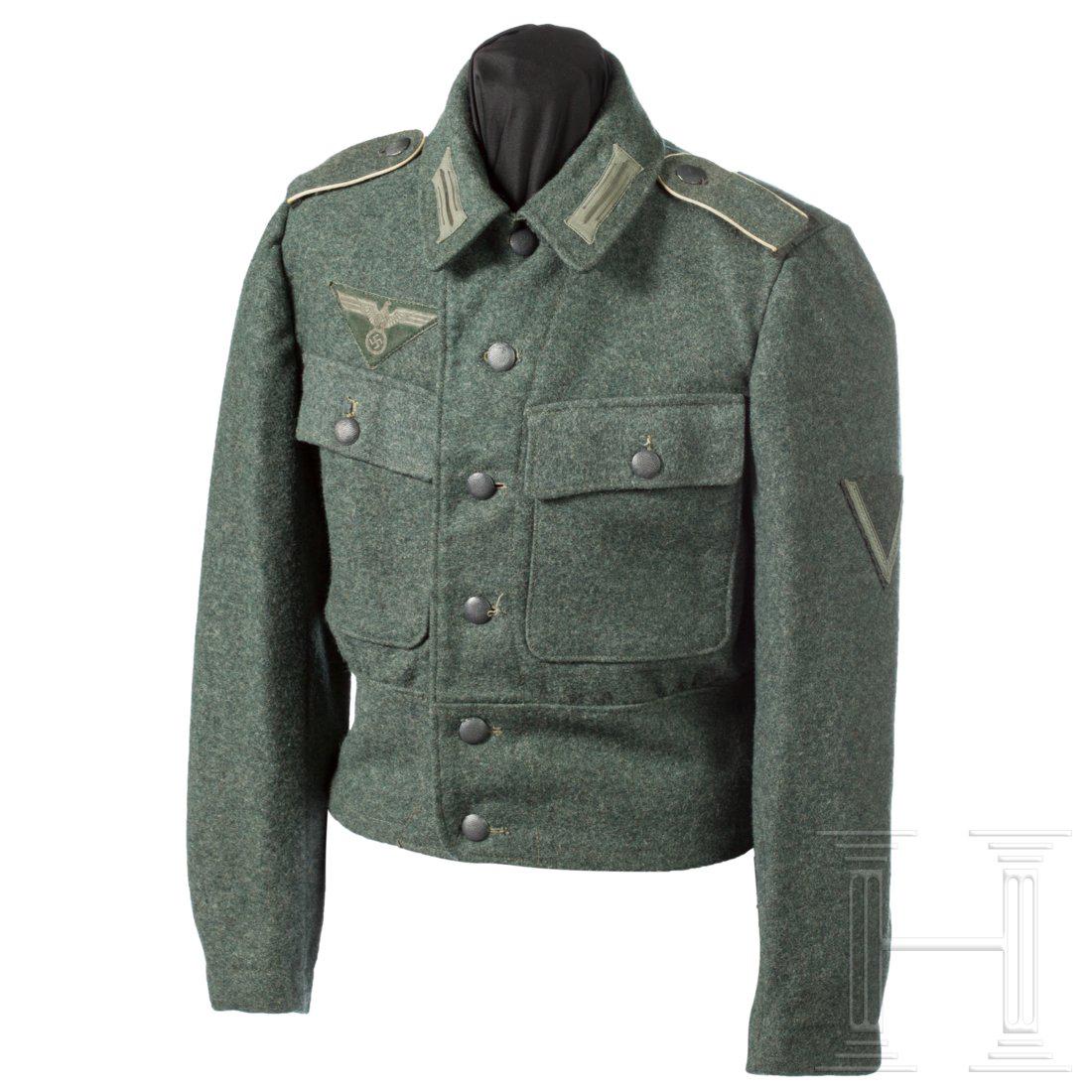 A fieldjacket M 44 for a privat in an infantry unit: KammerstÃ¼ck aus feldgrauem Spinnstoff mit einteiligem RÃ¼ckenteil, blaugrauen KnÃ¶pfen und grauem Baumwollfutter, die weiÃŸe Stempelung unleserlich. MaschinenvernÃ¤hte, mattgraue Einheitskr