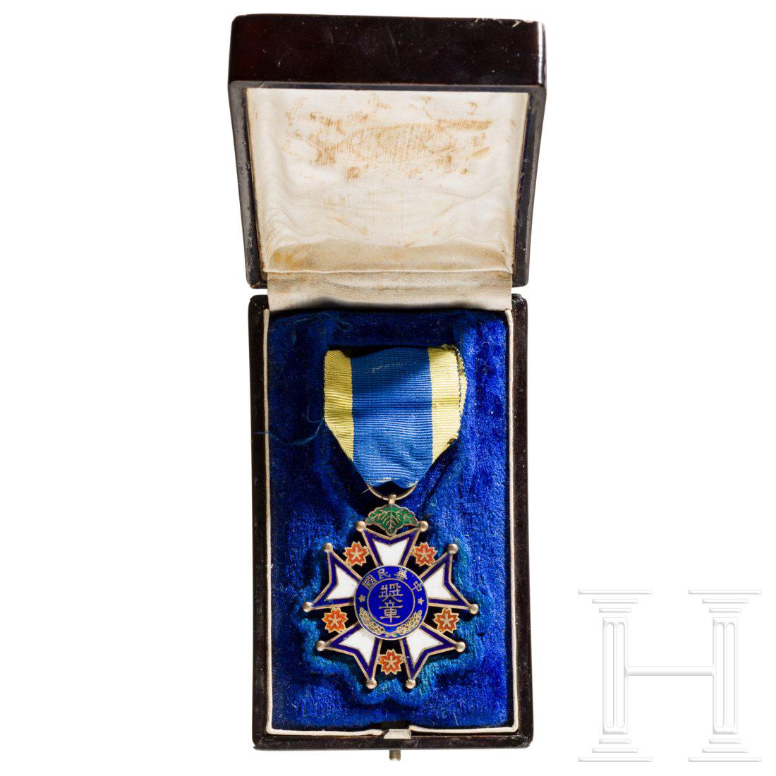 A Merit Medal 1st class of the Republic, Chinese: FÃ¼nfarmiges, farbig emailliertes Kreuz aus Silber mit aufgenietetem blauen Medaillon mit blauer Einfassung, der Bandring an Blattagraffe. Unsauber emailliert bzw. repariert. Durchmesser ca. 53 mm, 