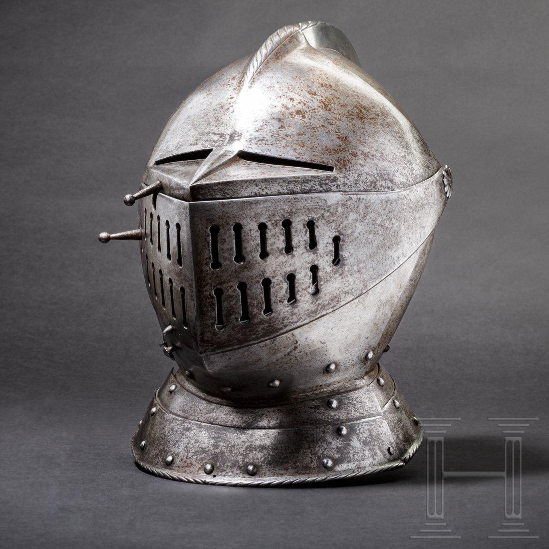 A historicism close helmet in the style of circa 1560: The skull forged in two pieces, with a false, roped comb. The plume socket with stippled dÃ©cor, riveted at the nape. The two-part, pivoted visor with separate eye holes and slot-shaped breathing ho