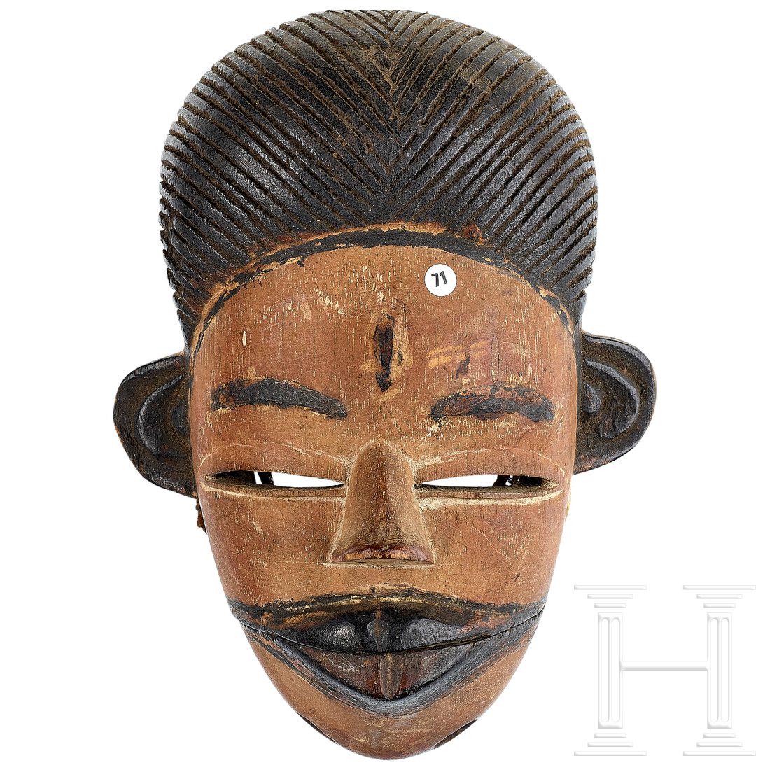 A mask of the Ibibio tribe, Nigeria: Farbig gefasste, anthropomorphe Maske mit beweglichem Kiefer und stilisierter Haarfrisur. Umlaufend BefestigungslÃ¶cher, leichte Gebrauchsspuren. HÃ¶he 19 cm. Condition: II -