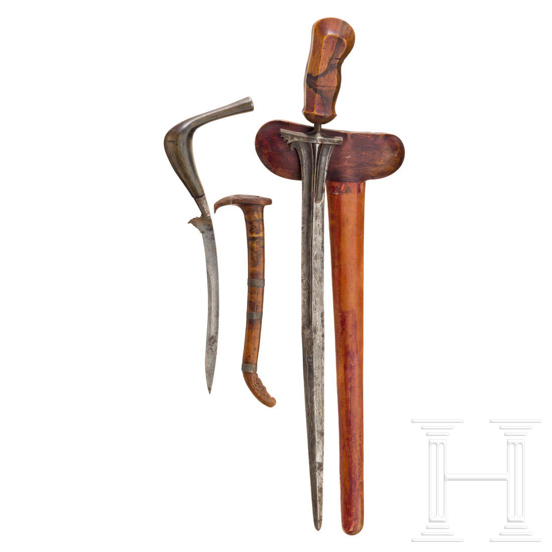 An Indonesian bade bade and kris, 19th century: Bade-Bade mit geschwungener feiner RÃ¼ckenklinge, geschnittener Wurzel und gebogenem Horngriff. Leicht beschnitzte und fein gravierte Holzscheide. LÃ¤nge 41,5 cm. Kris mit gerader Rasenerzklinge u
