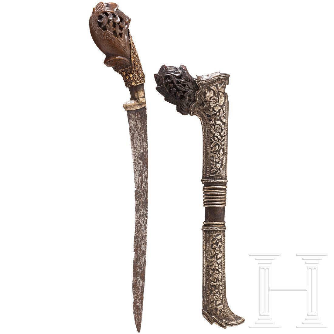 Tombok-Lada, Sumatra, 19. Jhdt.: RÃ¼ckenklinge aus Rasenerz-Damast (korrodiert). Fein geschnitzter Horngriff mit filigran gearbeitetem Goldbesatz. Scheide aus Holz und Horn mit reich reliefierter Silbermontierung (Fehlstelle). LÃ�