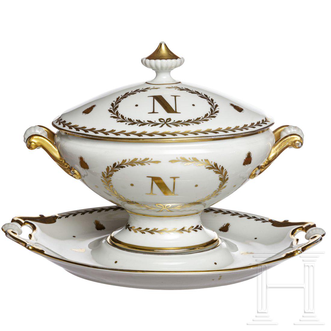 Napoleon I - a large patriotic terrine, 19th/20th: Glasiertes weiÃŸes Porzellan, teilvergoldet, ungemarkt. Deckelterrine nach klassizistischer Art mit goldener Initiale "N", kaiserlichem Adler, Bienen und Ranken. Dazu ein passender Untersatz. Kleine
