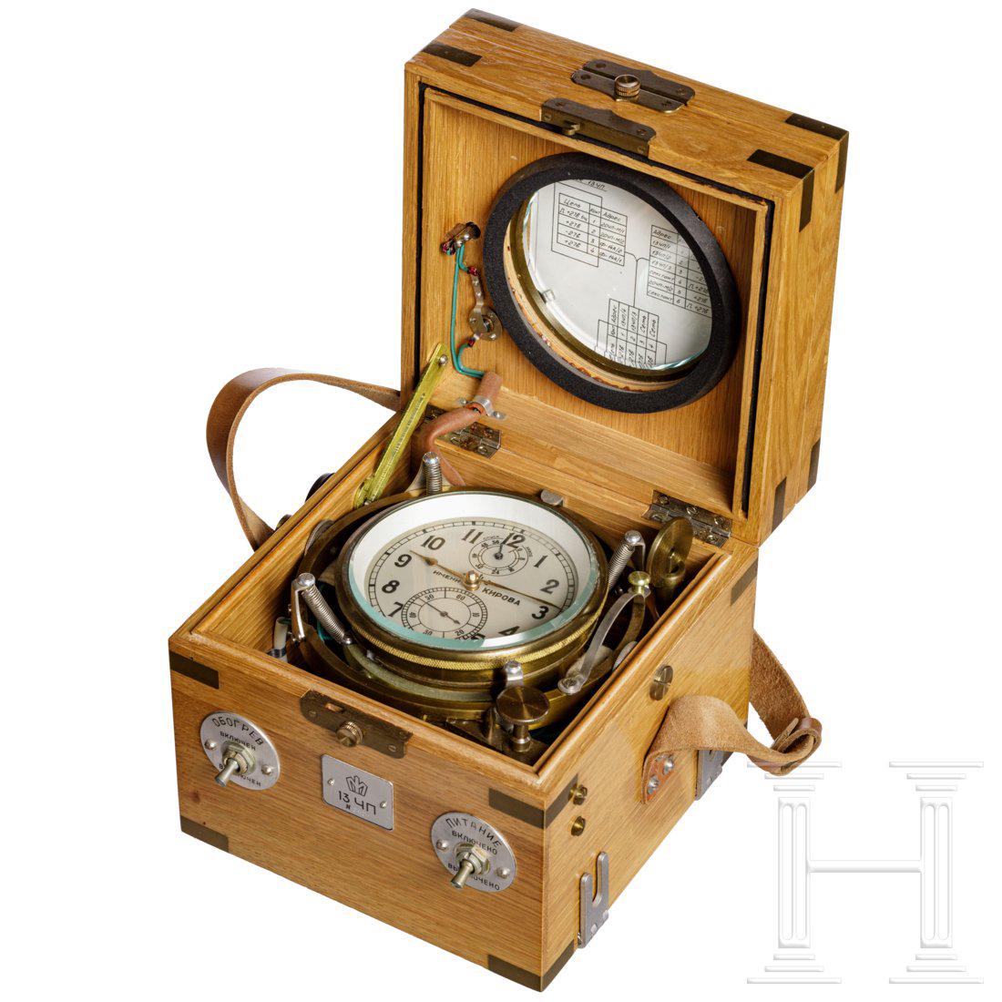 Elektrischer Flugzeugchronometer 13-20TschP-M von: Versilbertes Zifferblatt mit schwarzen Indizes, Gangreserveanzeige auf 12 Uhr und Sekundenanzeige auf 6 Uhr sowie Herstellerbezeichnung der 1. Moskauer Uhrenfabrik Kirowa. MessinggehÃ¤use in gefeder