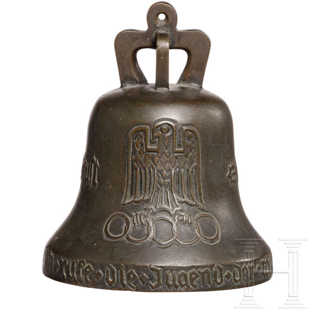 Olympic bell 1936: Bronze, reliefiert. Schauseitig der Adler mit den olympischen Ringen, auf der Gegenseite das Brandenburger Tor, Fraktur-Beschriftung. Komplett mit KlÃ¶ppel (AufhÃ¤ngung erneuert). HÃ¶he 11,5 cm.