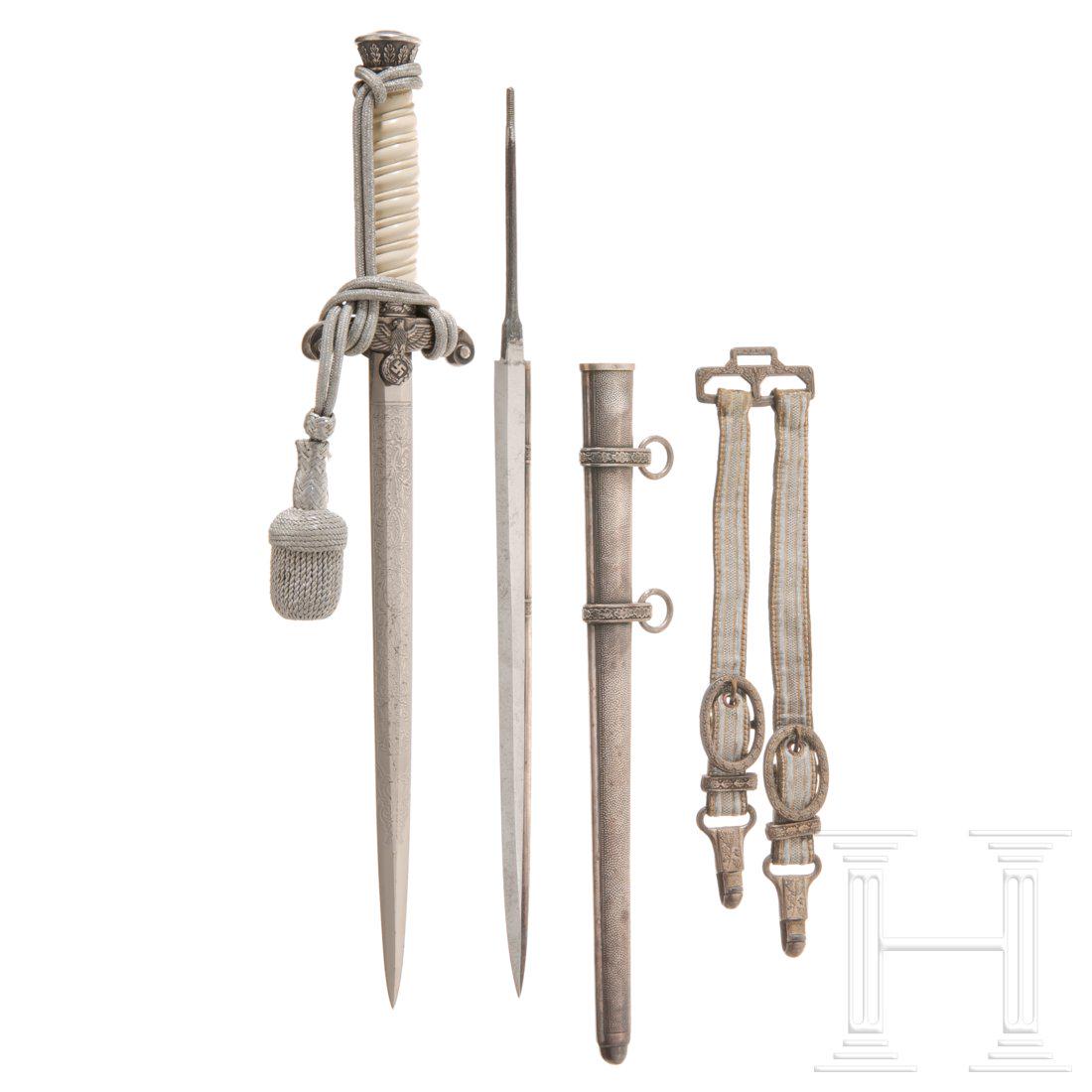 A dagger M 35 for officers of the infantry: Zusammengestellt. Beidseitig geÃ¤tzte Klinge (beschliffen) ohne Herstellerlogo. Knauf und Parierstange versilbert, mit weiÃŸem Kunststoffgriff. Versilberte Eisenscheide. Getragenes LuxusgehÃ¤nge