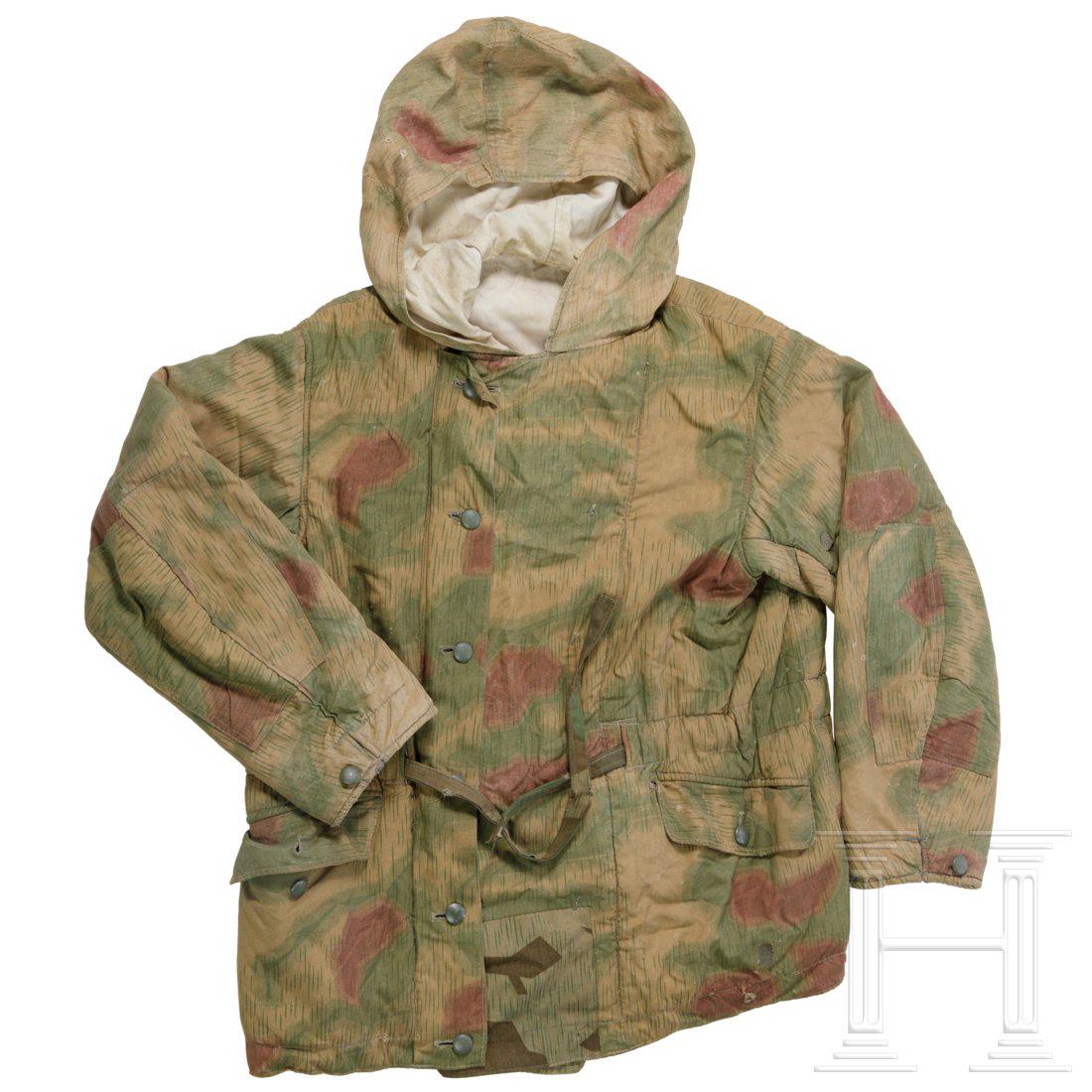 A reversible winterjacket in tan/water camoflage: Wendbar von der weiÃŸen Winter- auf die FrÃ¼hlings- bzw. Herbstseite in Sumpftarnmuster, in dick wattierter AusfÃ¼hrung mit UniformknÃ¶pfen. Beide Seiten in gleicher Ausstattung, zweireihig mi