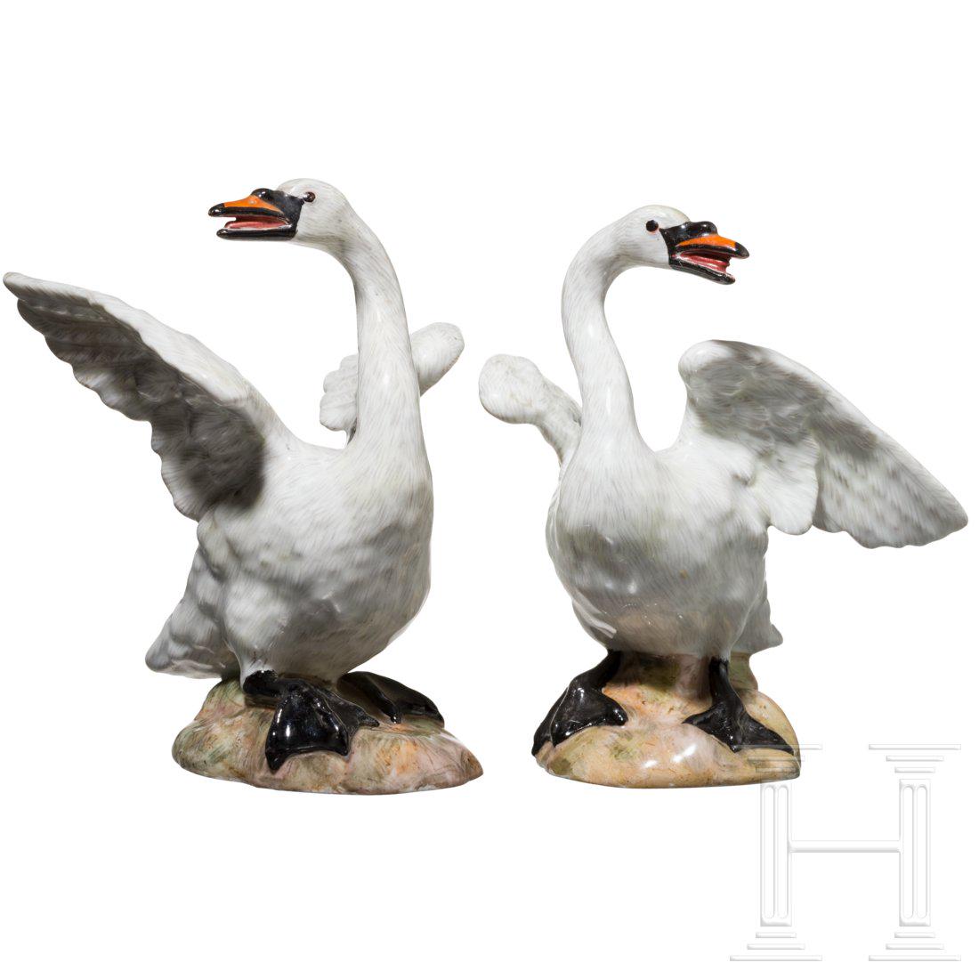A pair of porcelain swans, Meissen, 19th century: Fully plastic porcelain with colourful decorations. The swans on small naturalistic base. Worked as counterparts. Remains of the blue sword mark and model number at the bottom. Height 10/10.5 cm. Good