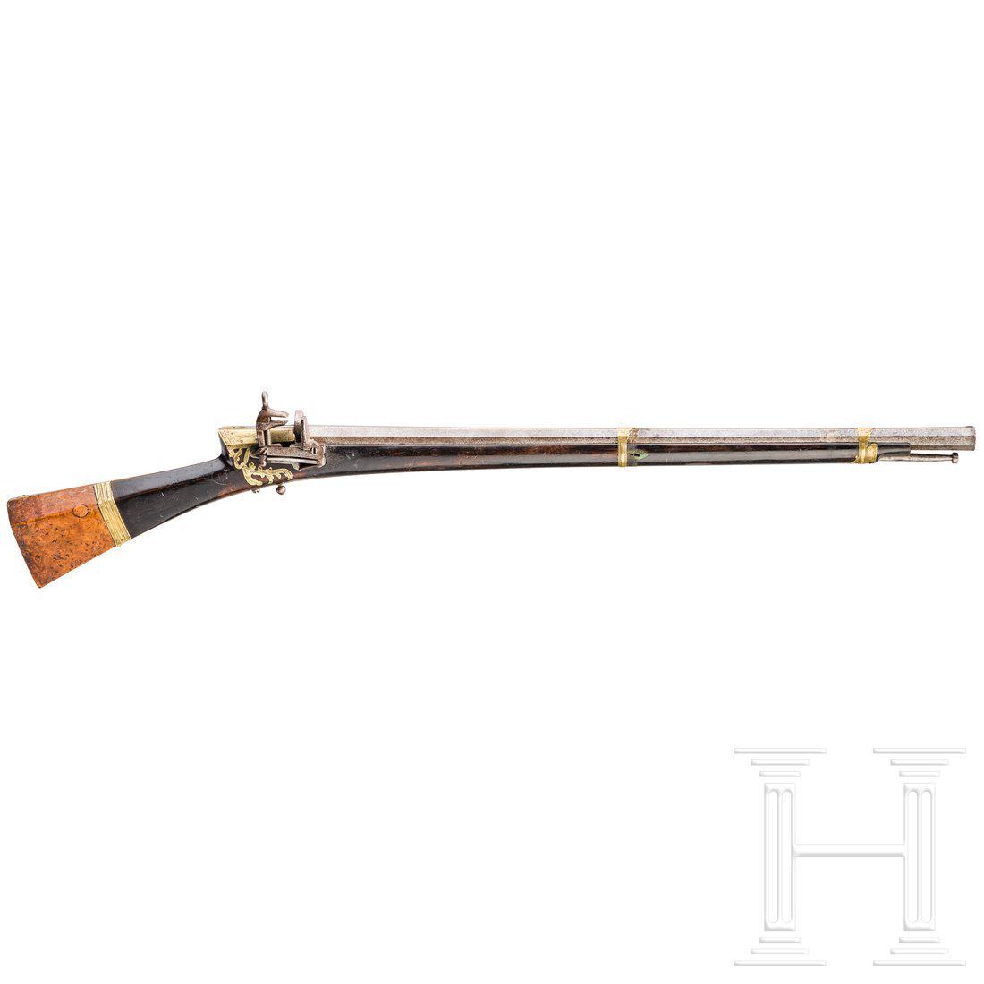An Ottoman miquelet rifle (tÃ¼fek), 18th century: Achtkantiger, siebenfach gezogener Lauf aus Rosendamast mit Kupferkorn und dreifach gelochter Standkimme. Leicht floral graviertes Miqueletschloss mit dunklem Holzschaft, um die Schwanzschraube und Sc