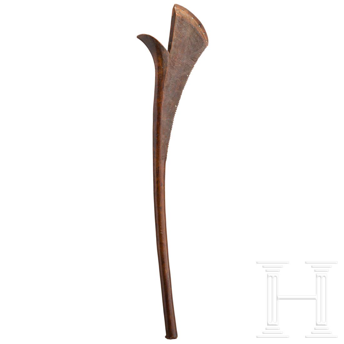 A Fijian Sali war club: The broad head with a raised ridge and serrated striking edge (one small defect), a ridged beak, the entire head embellished with fine geometric carvings down to the shaft. The slightly curved shaft w