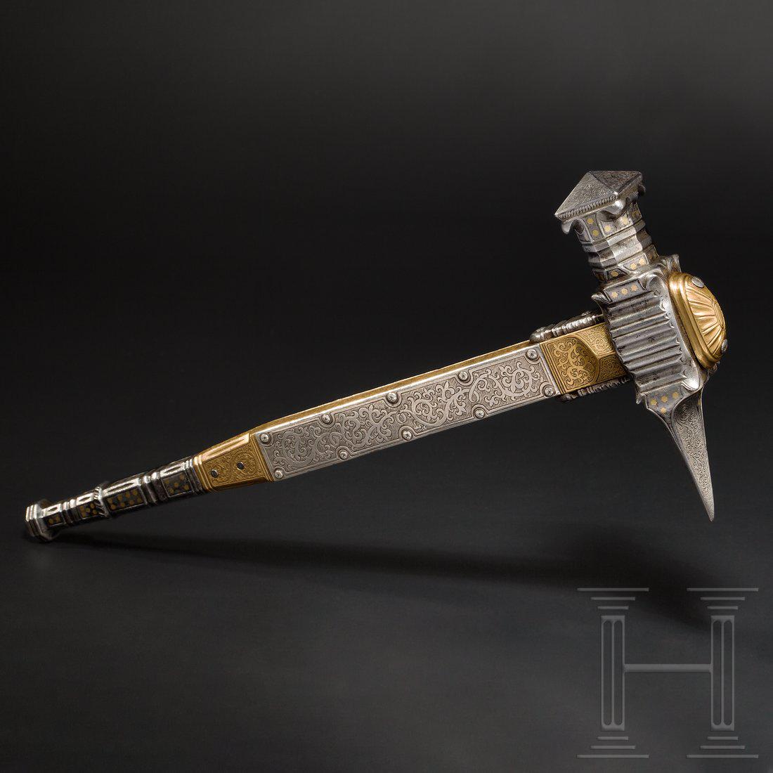 A Nuremberg ceremonial war hammer, dated 1581: Iron hammer head with short, quadrangular back spike, profusely chiselled socket and quadrangular hammer head. Finely engraved surfaces with scrolling leaves, partially star-shaped brass inlays. Fulle