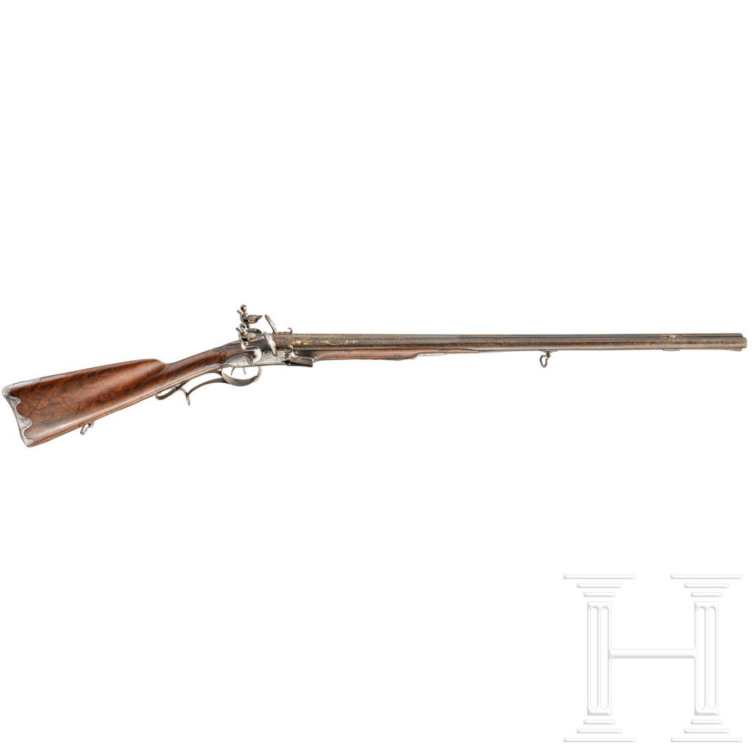 A gold-damascened flintlock side-by-side shotgun by: Blued, smooth and round barrels in 15 mm calibre with patent breechblock and silver front sight. At the breeches a gold-damascened trophy bundle and St. Etienne acceptance mark, on the midrib the gold