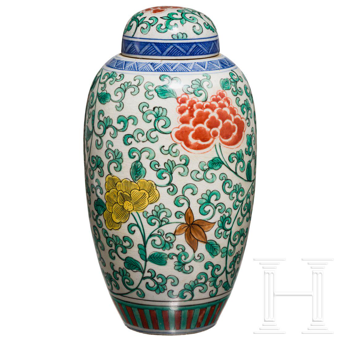 A Chinese famille verte vase with lid, late Qing era,: Famille verte vase with high, almost slender body. Typical floral decoration in green, yellow, red and ochre. Blue-decorated neck. Good old colours, the glaze a little matt due to its age. Relatively 