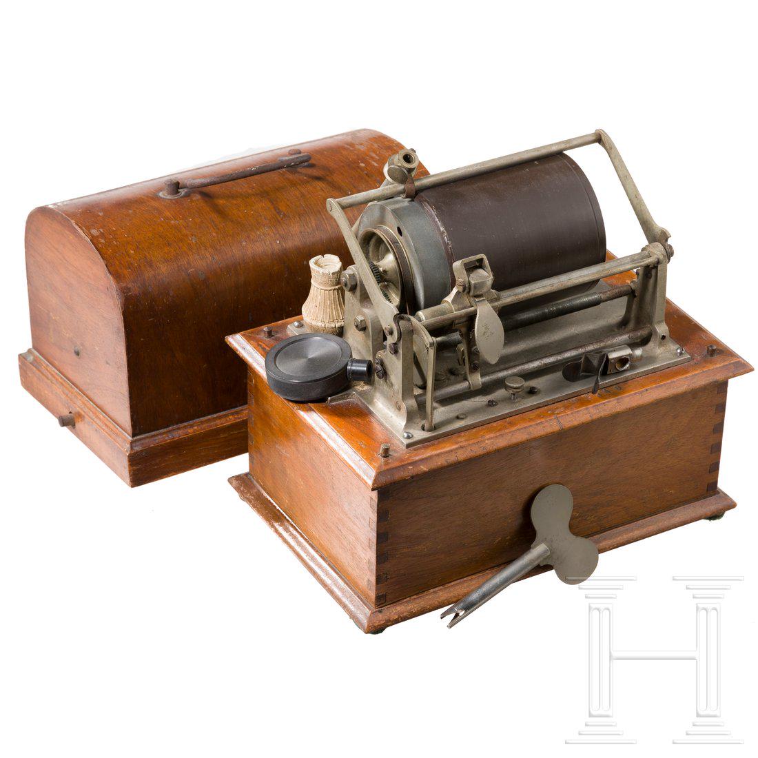 A French phonograph by PathÃ© FrÃ¨res, Paris, circa: Phonographenmechanismus in HolzgehÃ¤use mit halbrundem, abnehmbarem Schutzdeckel, auf dem TonabnehmerbÃ¼gel Hersteller und Patentdaten, auf dem Zylinder an der Schmalseite Titel des MusikstÃ¼cke