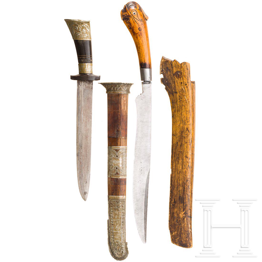 Zwei Pedang, Sumatra, um 1900: Gerade bzw. an der Spitze verbreiterte RÃ¼ckenklingen mit neusilbergefasstem Horn- bzw. Holzgriff mit Knauf in Form eines Vogelkopfes. ZugehÃ¶rige Holzscheiden, ein Exemplar mit ornamental getrieb