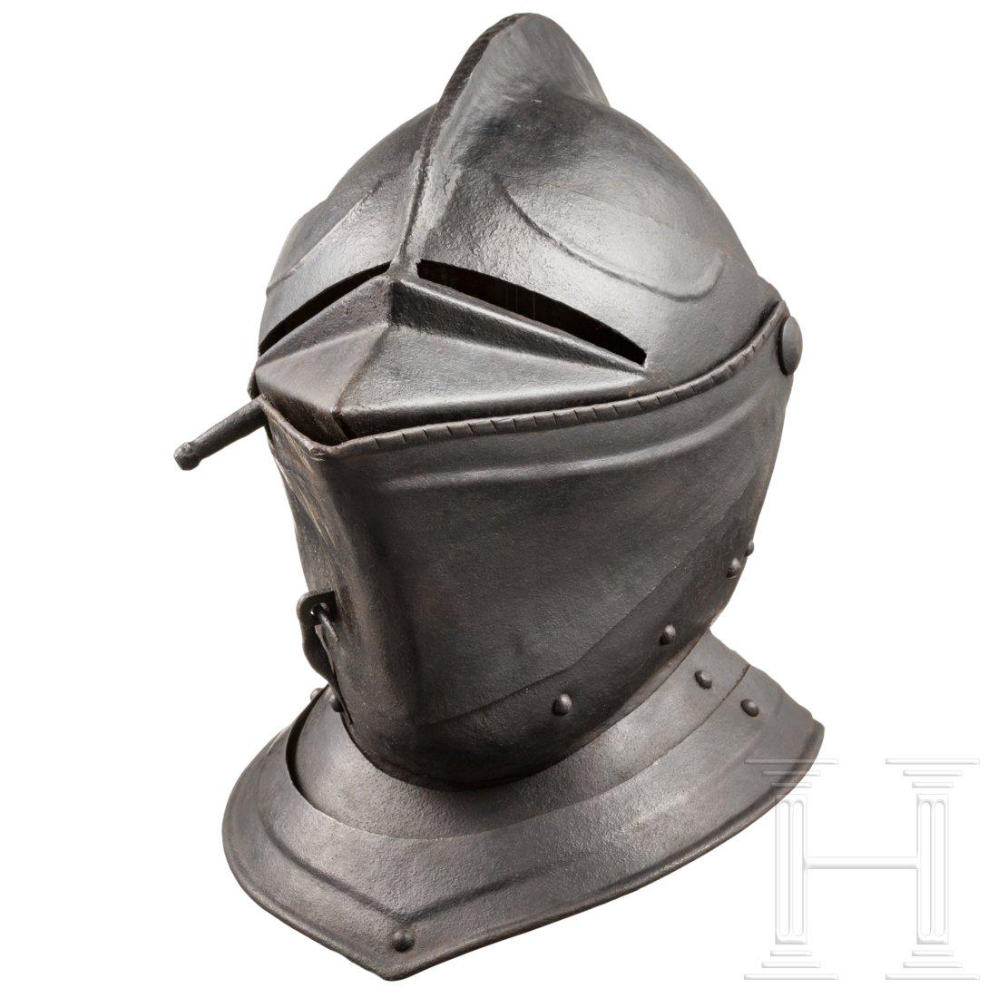 A close helmet, historicism in the style of circa 1570: The skull forged in two pieces with a tall, roped comb. The pivoted two-part visor with separate eye slits. The chin guard with two hook-and-eye closures, the two riveted neck lames with turned and ro
